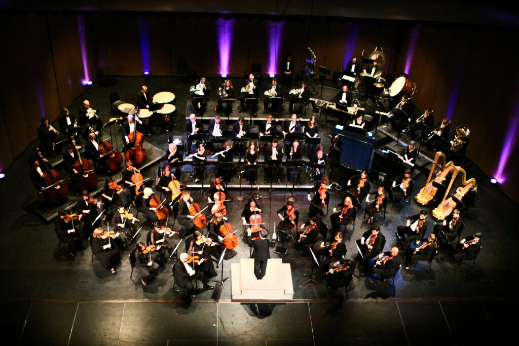 Overhead view of a full orchestra performing on stage.