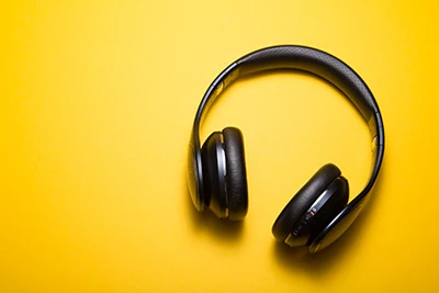 Black headphones on a yellow background.